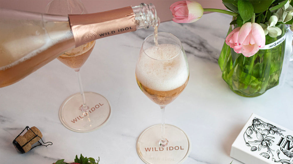 Strawberries, flowers and Wild Idol's non alcoholic sparkling rose on a table