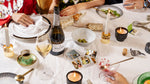 A glass and bottle of Wild Idol Alcohol Free Sparkling White Wine standing on a festive party table
