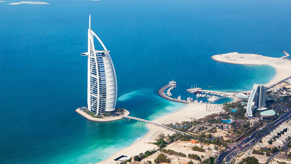 Aerial view of the Burj Al Arab hotel and Jumeirah Beach in Dubai, with clear blue waters. Enjoy non alcoholic champagne Dubai style.