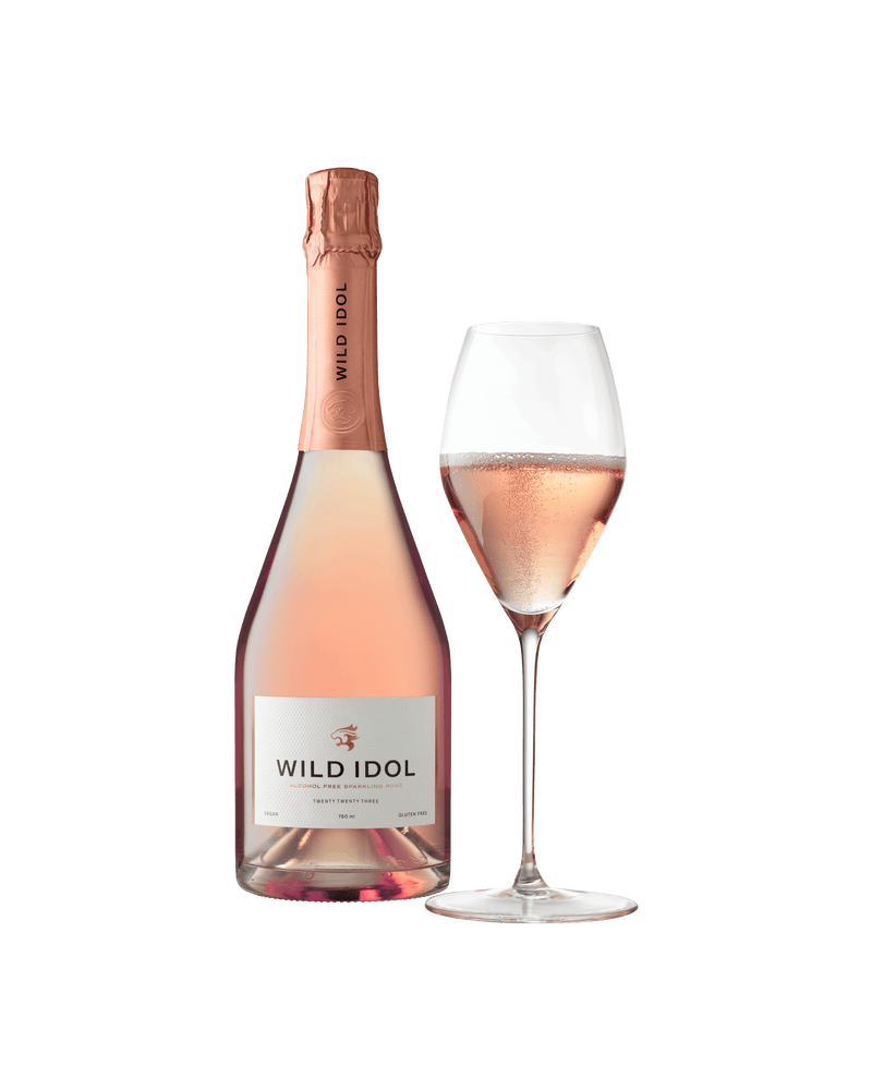 A glass of Wild Idol Alcohol Free Sparkling Rosé Wine next to its bottle