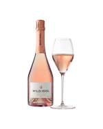 A glass of Wild Idol Alcohol Free Sparkling Rosé Wine next to its bottle