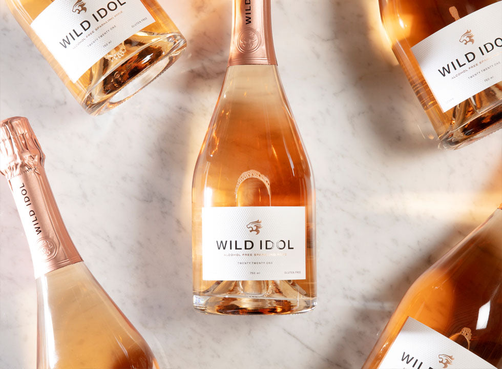 Multiple bottles of Wild Idol Alcohol Free Sparkling Rosé Wine lying next to each other